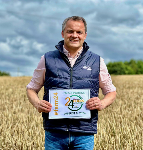 AHDB CEO in a wheat field holding a farm24 sign